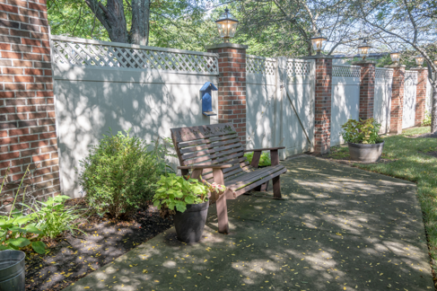 A peaceful garden space featuring a wooden bench surrounded by greenery.