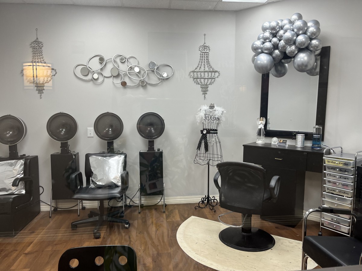 A chic hair salon interior with styling chairs, hair dryers, and elegant decor.