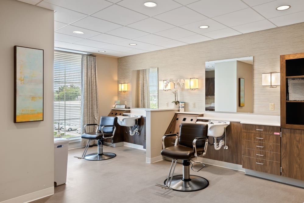 A modern and clean salon interior with styling chairs and mirrors.