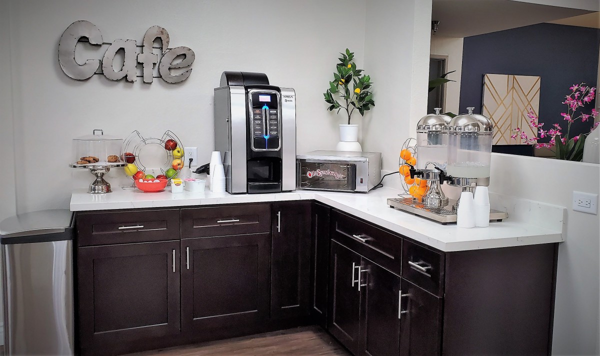 A modern kitchen corner with a coffee maker, microwave, and various decorative items on the countertop.