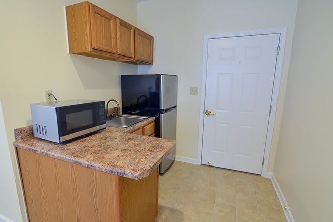 A compact kitchen area with essential appliances and cabinetry.