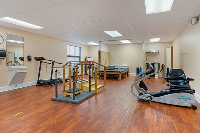 A well-equipped rehabilitation gym with treadmills and therapy equipment.