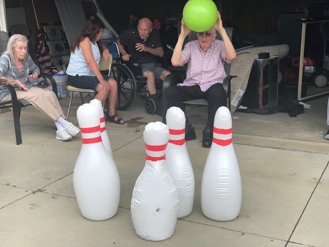 A group of people enjoying an outdoor inflatable bowling game.