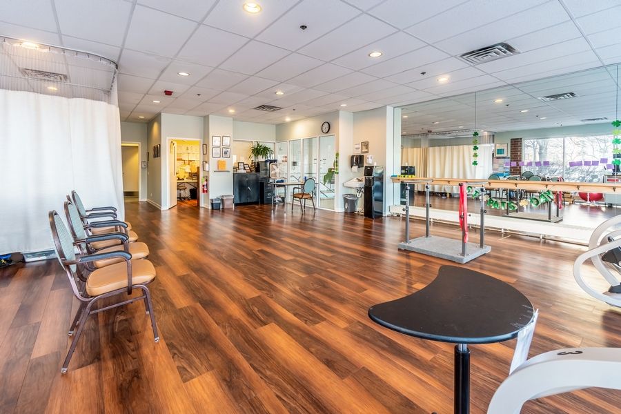 A spacious fitness center interior with wooden flooring and various exercise equipment.