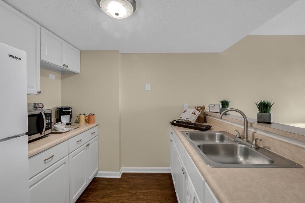 A modern kitchen with white cabinets and appliances.