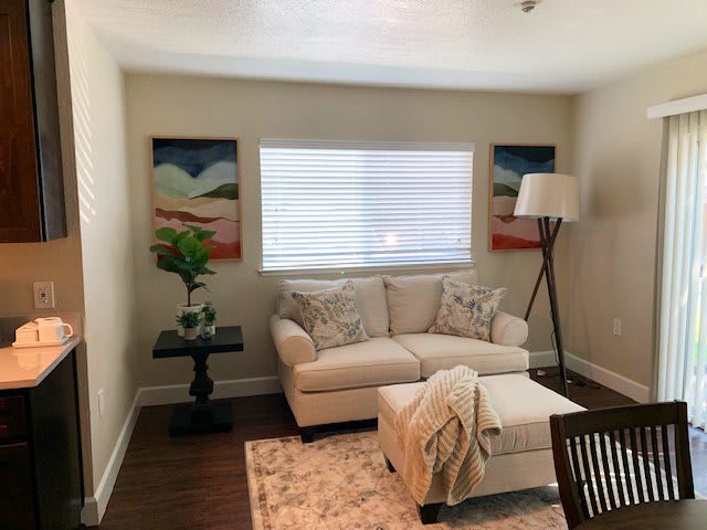 A cozy living room with a beige sofa, artistic wall decor, and a warm ambiance.