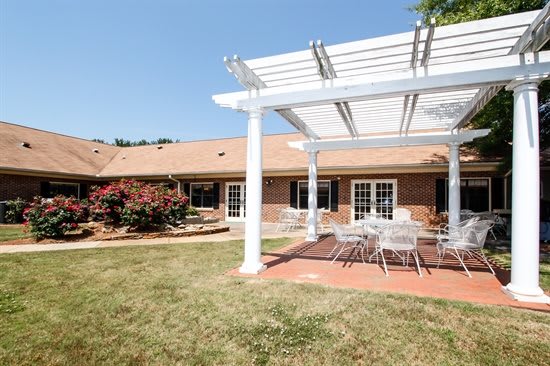 A backyard patio with a pergola and outdoor seating area.