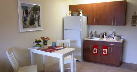 A cozy kitchen with a dining table, chairs, and essential appliances.