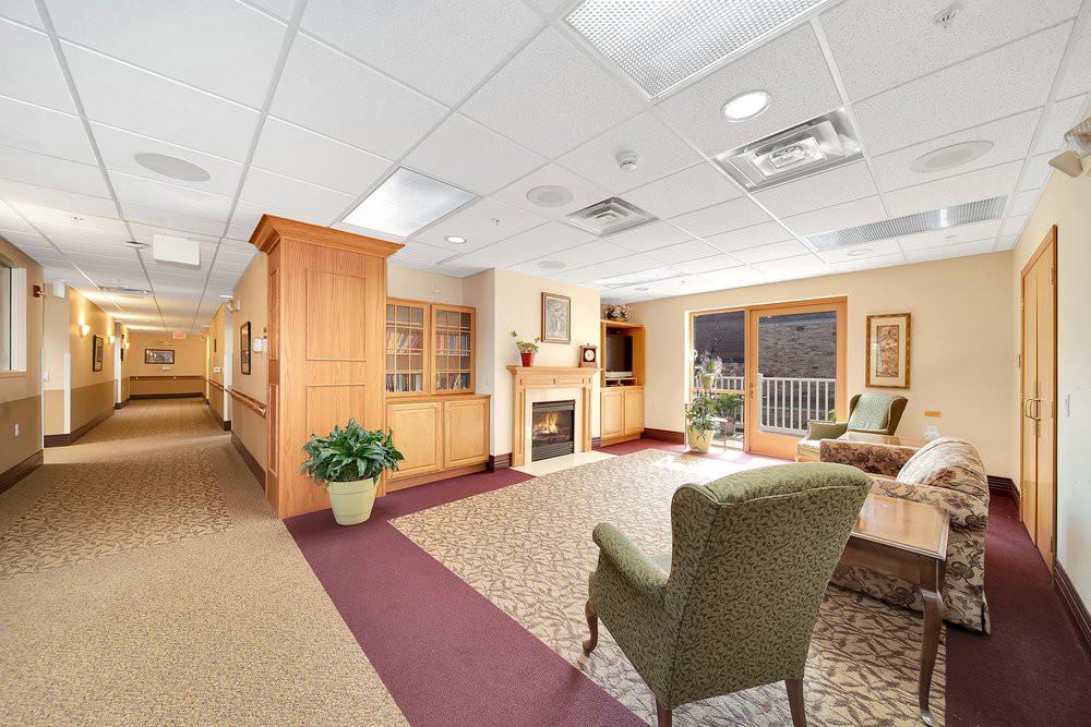 A cozy lobby area with comfortable seating, a fireplace, and decorative elements.