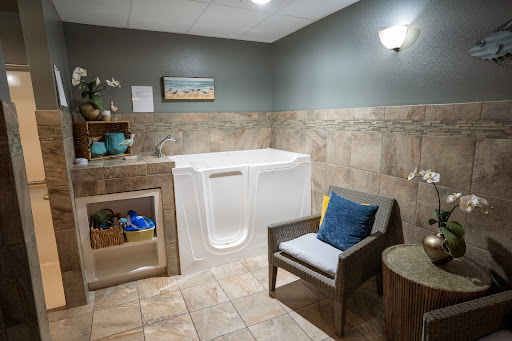 A tranquil bathroom featuring a walk-in tub and comfortable seating.
