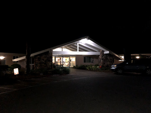 A well-lit modern building at night with a welcoming entrance.