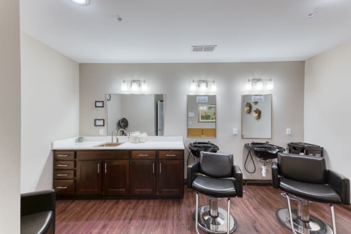 A modern hair salon with styling chairs and well-lit mirrors.