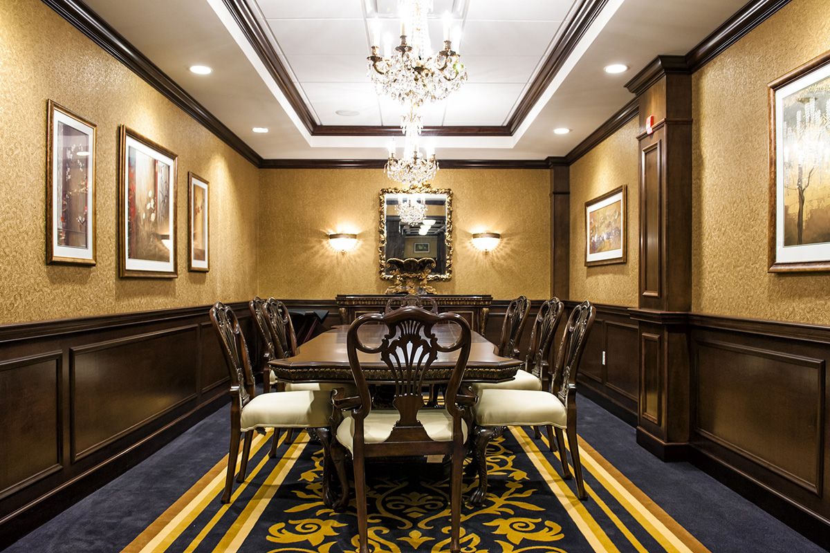 A luxurious and elegant dining room with a chandelier and formal wooden furniture.