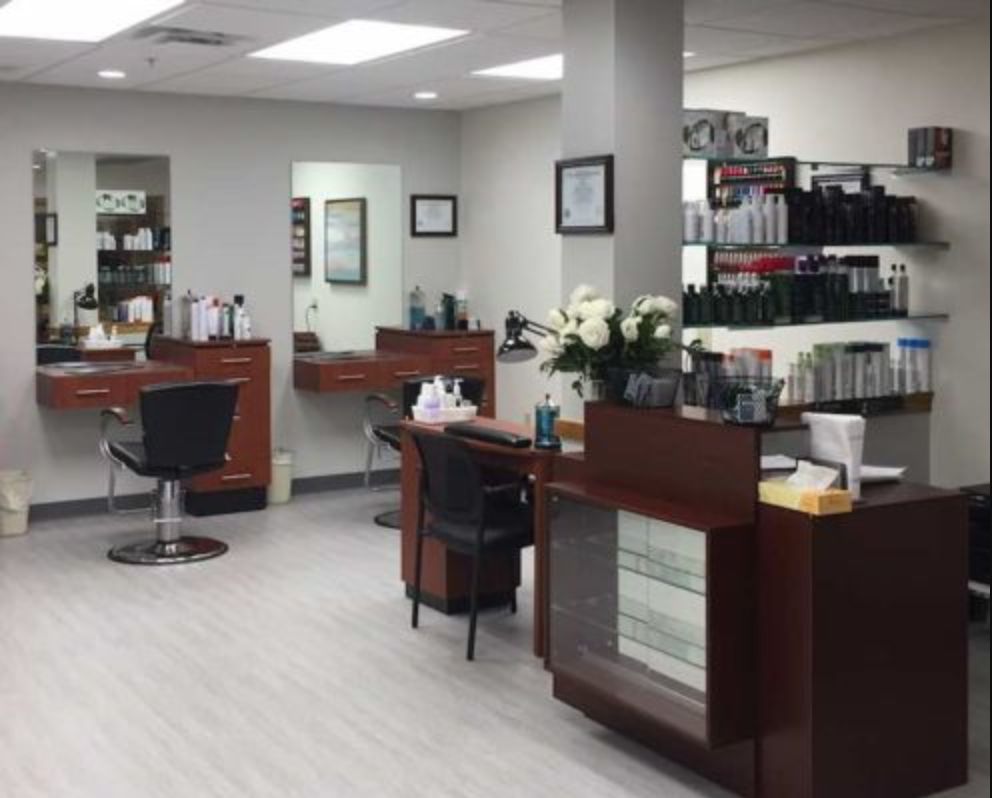 Interior view of a modern hair salon with styling stations and product displays.