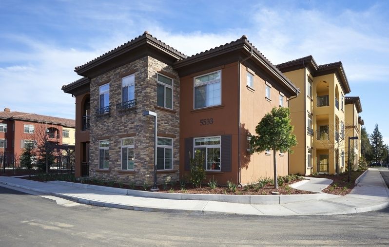 A modern two-story residential building with a mix of stone and stucco exterior.
