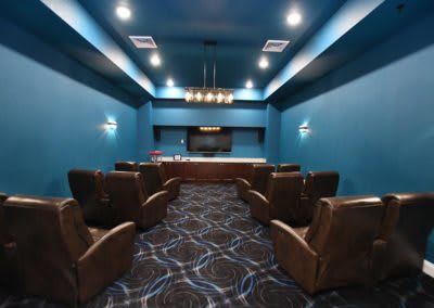 A modern home theater with comfortable seating and a large projector screen.