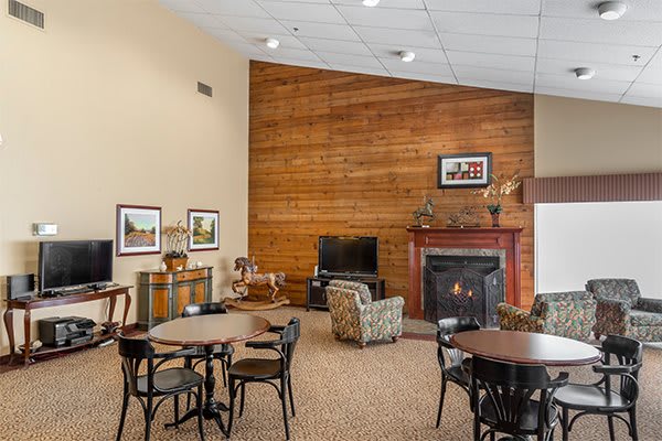 A cozy living room with wood paneling, a fireplace, and comfortable seating arrangements.