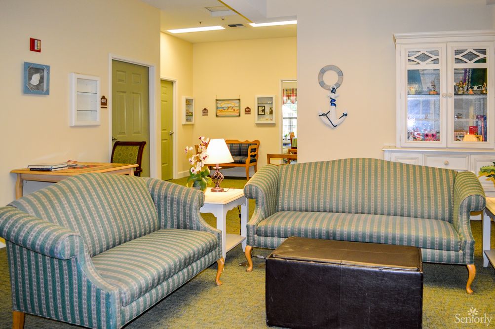 A cozy living room with striped sofas, a coffee table, and nautical decor.