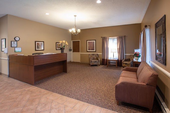 A spacious and warmly decorated lobby area with a reception desk and seating.