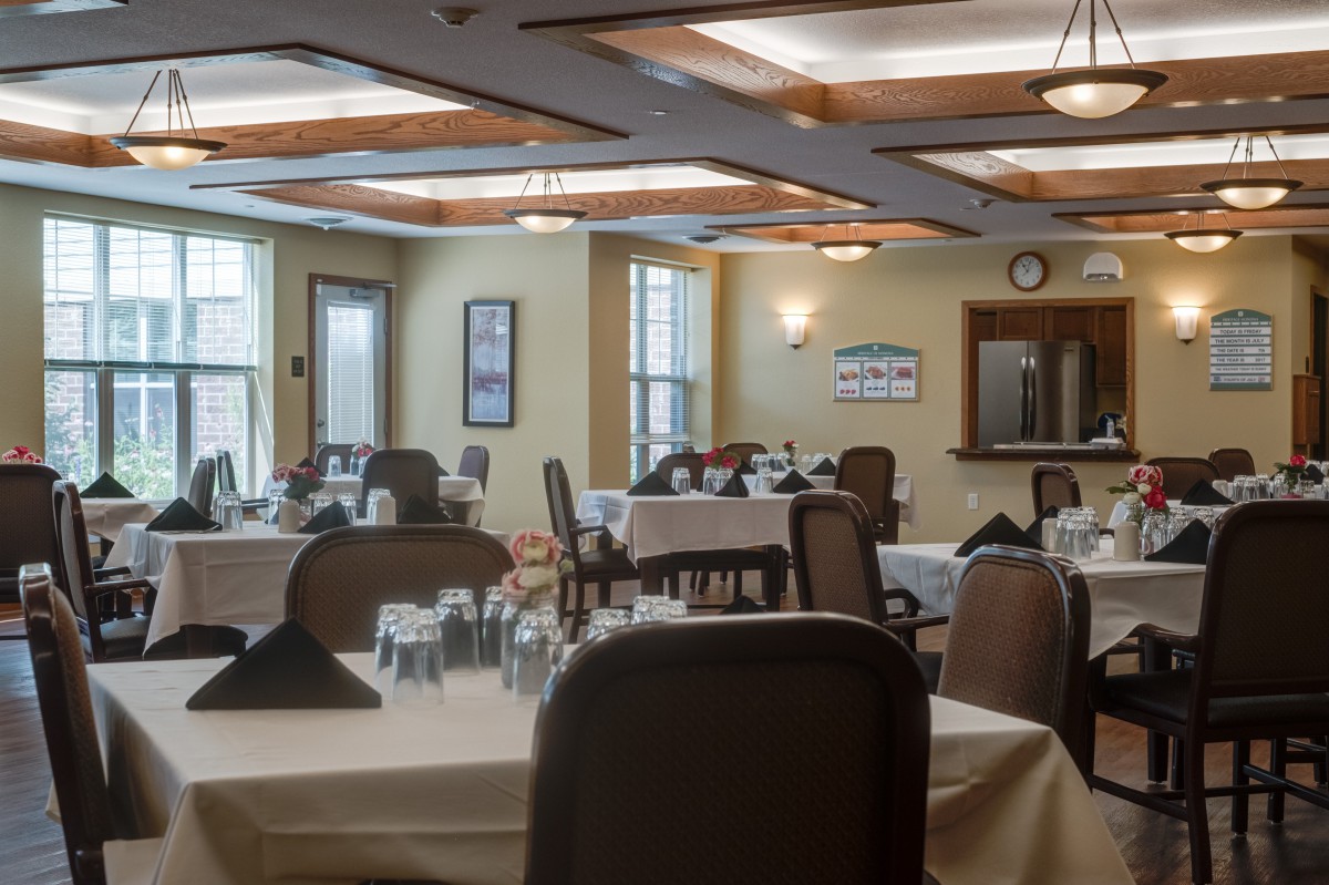 An empty dining room with neatly arranged tables and chairs, prepared for guests.