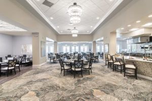 An elegantly decorated dining room with chandeliers, featuring neatly arranged tables and chairs.