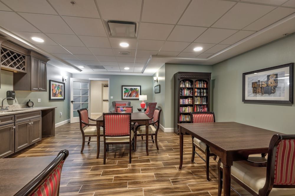 A cozy communal dining area with a bookshelf and comfortable seating.