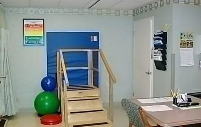 A physical therapy room equipped with stairs, gym balls, and exercise equipment.