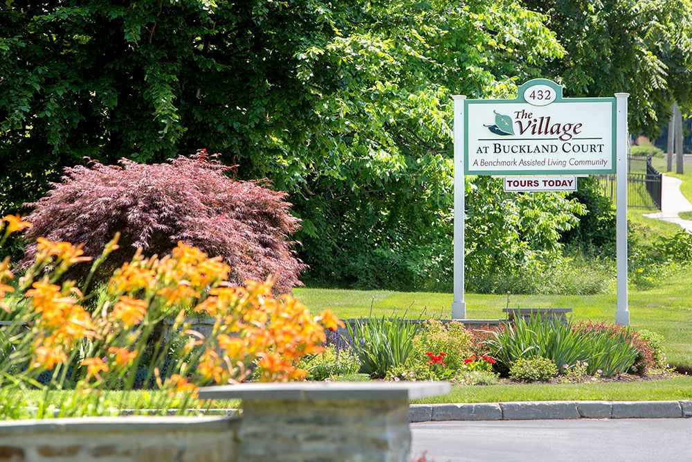A picturesque entrance sign surrounded by vibrant flowers and lush greenery.