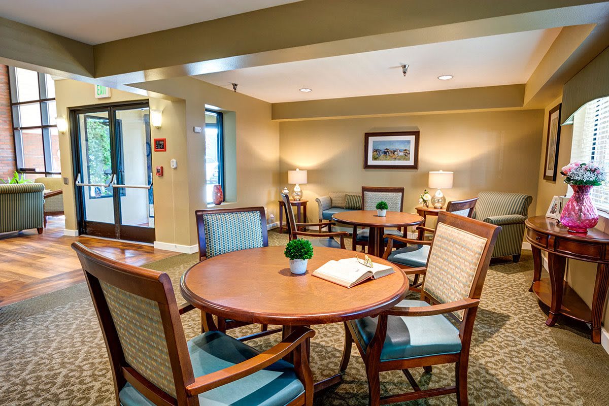 A cozy and well-decorated seating area with tables and chairs, illuminated by soft lighting.