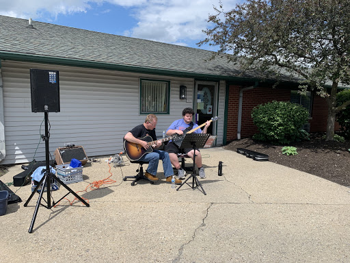 Two musicians enjoying an outdoor jam session on a sunny day.
