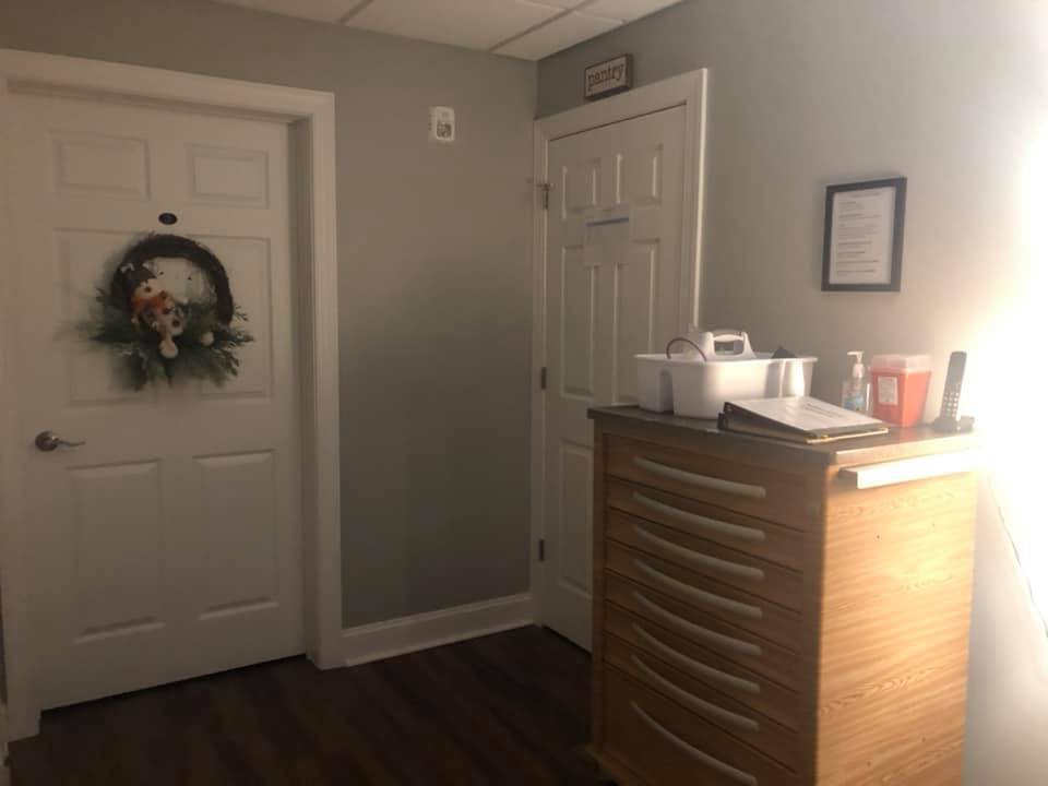 A cozy office or waiting room with a decorative wreath on the door and a wooden cabinet.