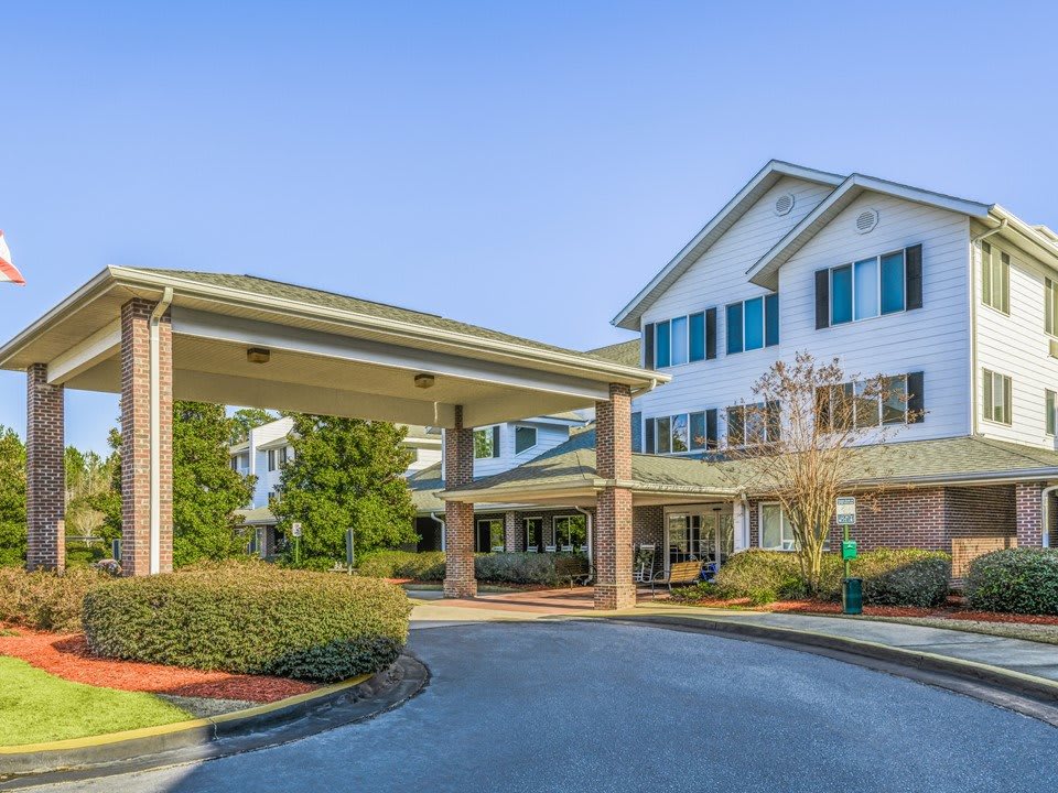 A well-maintained residential building with a covered entrance and landscaped surroundings.