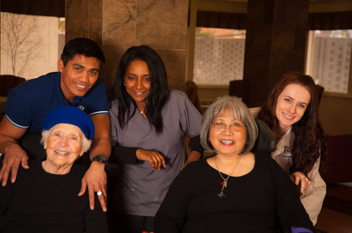 A warm gathering of caregivers and residents sharing smiles together.