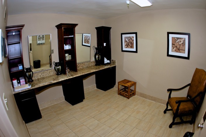 A spacious bathroom with a double sink vanity, large mirrors, and decorative artwork on the walls.