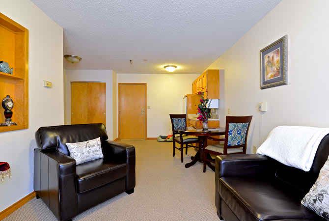 A cozy living and dining area with leather chairs and warm lighting.