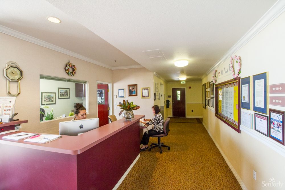 A receptionist attending to a visitor in an office lobby.
