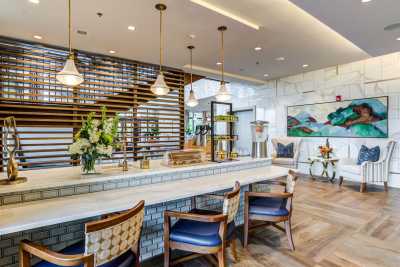 A modern restaurant interior featuring a stylish bar area with pendant lighting and decorative elements.