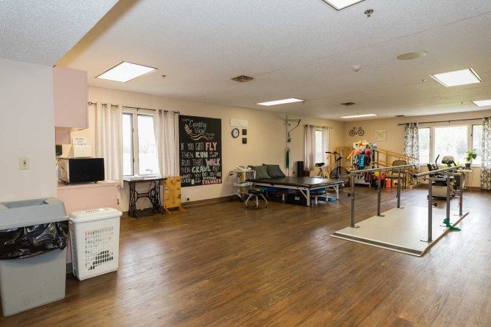 A spacious therapy room equipped with various exercise tools in a healthcare facility.