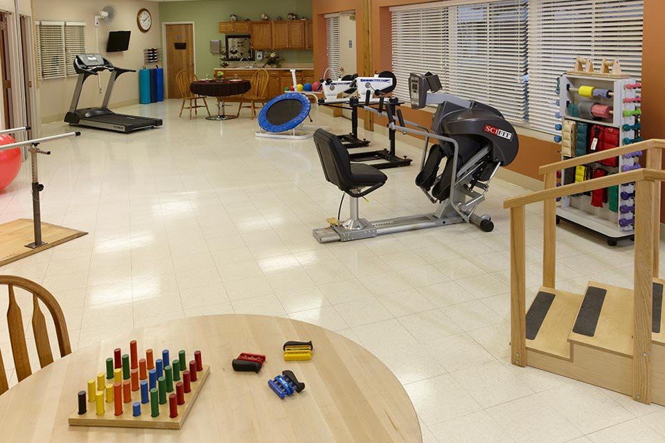A physical therapy room equipped with various exercise machines and tools for rehabilitation.