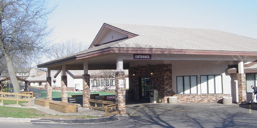 The entrance of a commercial building featuring a stone facade and a sloped roof.