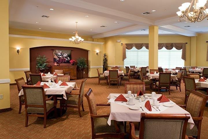 An elegant dining room with neatly arranged tables and chairs, set for a meal.