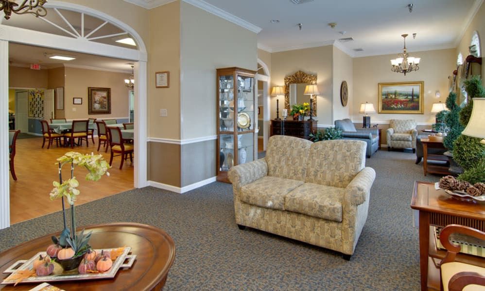 A cozy living room area featuring a patterned sofa and a wooden coffee table, with elegant decor and warm lighting.