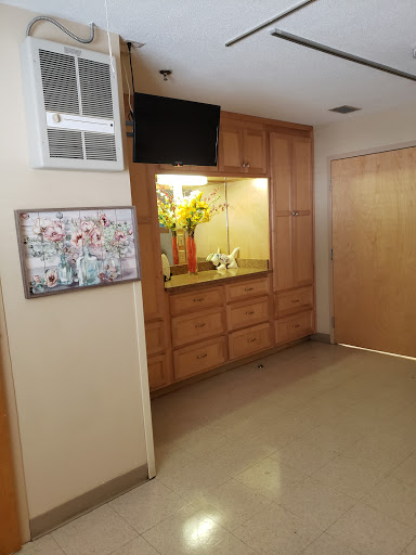 A spacious interior featuring wooden cabinetry, a mounted television, and decorative artwork.