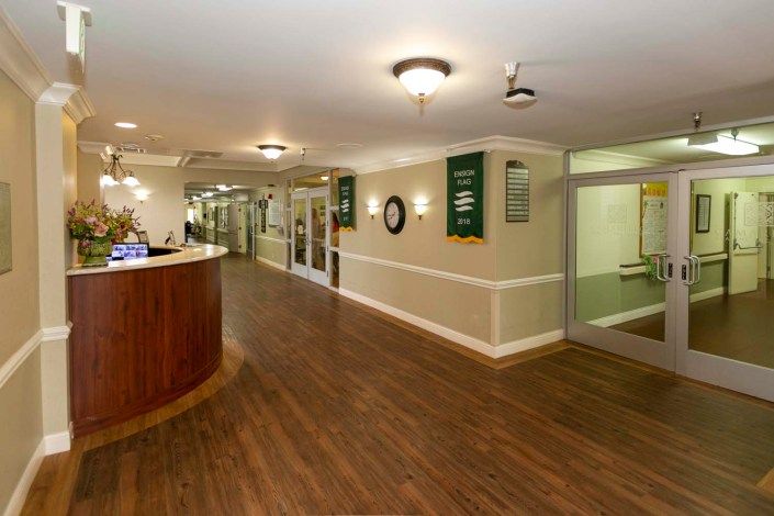 A spacious reception area with wooden flooring and ambient lighting.