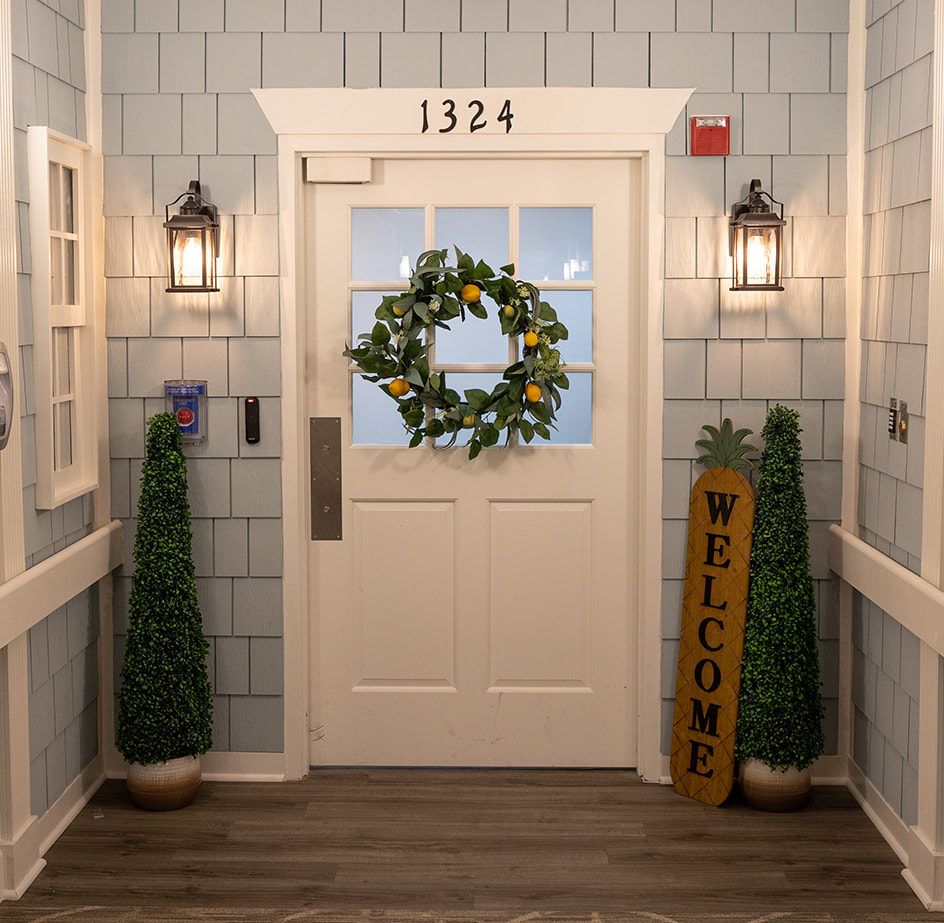 A welcoming entrance with a decorative wreath and plants.