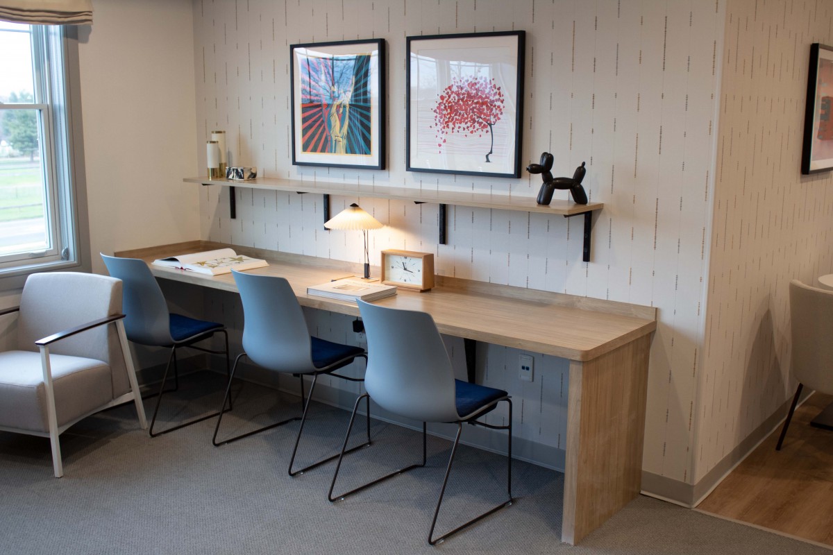 Contemporary workspace with a wooden desk, modern chairs, and decorative artwork.