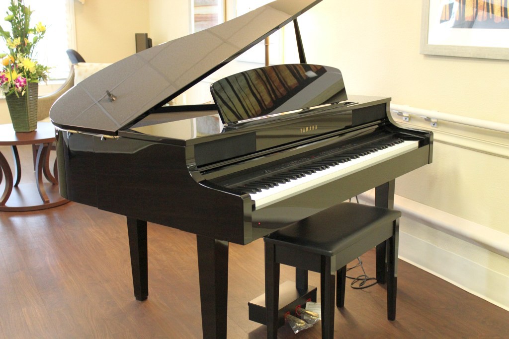 A black grand piano in a music room setting.