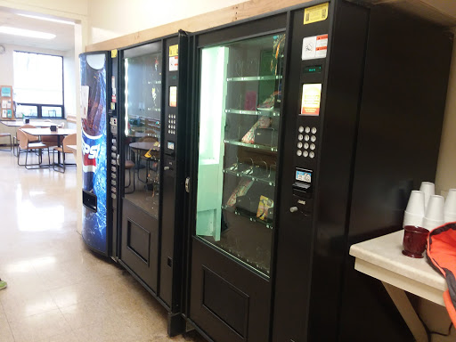 A row of vending machines offering snacks and drinks in a communal area.