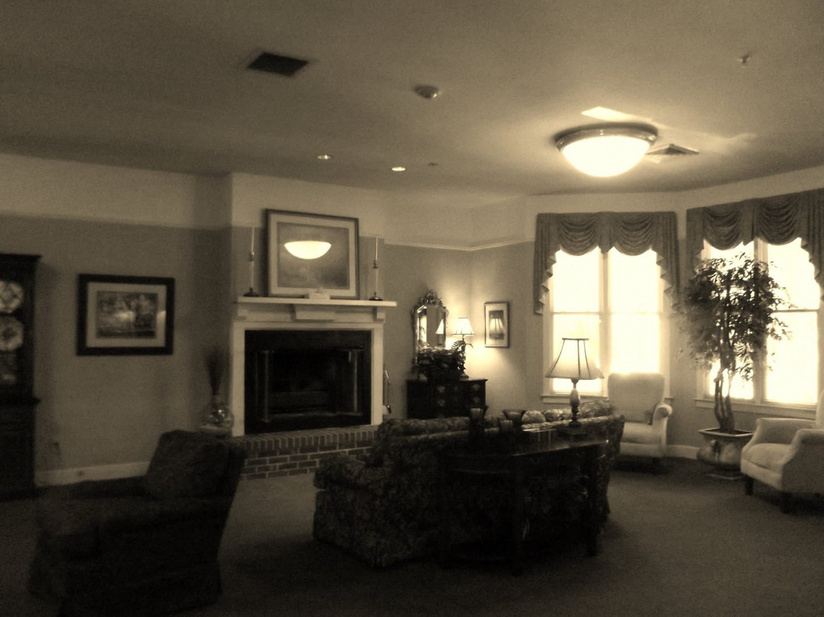 A vintage-style living room with a fireplace, comfortable seating, and soft lighting.