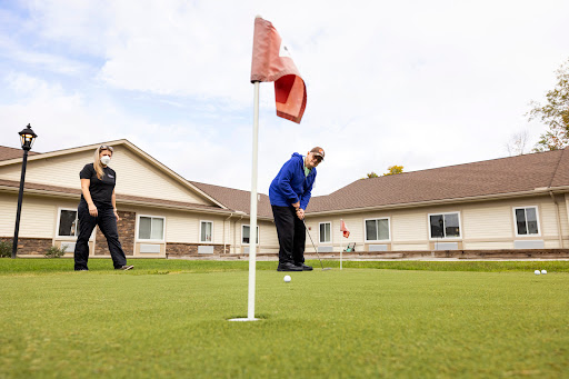 Two individuals enjoying a game of golf on a sunny day.